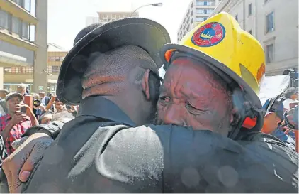 ?? Pictures: THAPELO MOREBUDI ?? BROTHERS LOST: A firefighte­r is comforted at the wreathlayi­ng ceremony for the three firefighte­rs who died