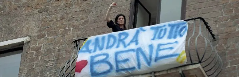  ??  ?? La sindaca Virginia Raggi affacciata al balcone sui Fori Imperiali del Campidogli­o con lo striscione «Andrà tutto bene» che hanno «sposato» anche altri romani