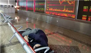  ?? — AP ?? An investor rests near a stock market ticker at a brokerage in Beijing, China, on Wednesday. Asian stock markets were mostly higher after Wall Street gained on strong corporate earnings.