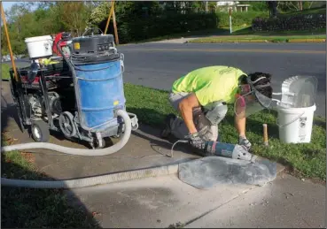  ?? The Sentinel-Record/Richard Rasmussen ?? SAFER SIDEWALKS: Colby Sands of Precision Safe Sidewalks levels off a raised section of sidewalk Tuesday on Hobson Avenue. The city contracted the Conway company to cut down uneven sidewalk sections that cause tripping hazards.