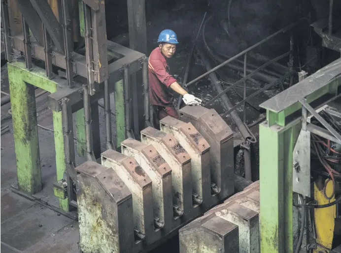  ??  ?? A worker is seen at a hot rolling production line at the Chongqing Iron and Steel plant in the Changshou district of Chongqing, China, Aug. 6, 2019.