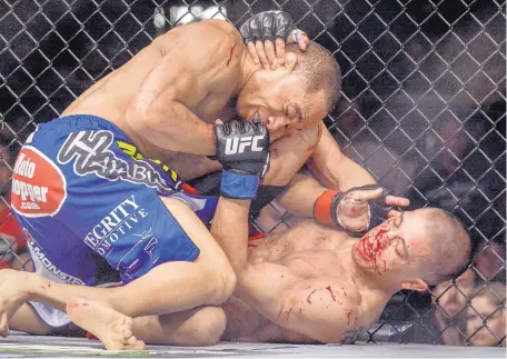  ?? ROBERTO E. ROSALES/JOURNAL ?? Albuquerqu­e’s John Dodson, left, pounds away on John Moraga during a UFC Fight Night in 2014 held at Tingley Coliseum.