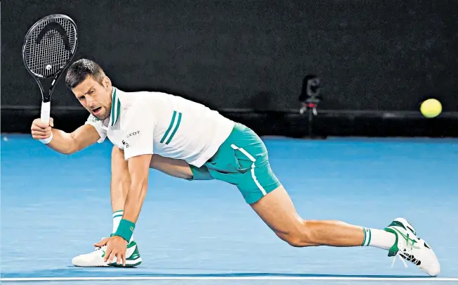  ??  ?? Full stretch: Novak Djokovic does not spare his body in returning against Milos Raonic