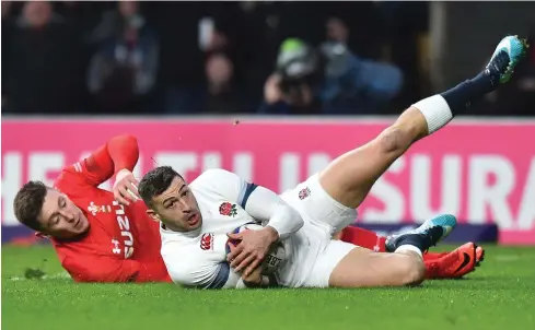  ?? AFP ?? England winger Jonny May, front, scores a try against Wales at the Twickenham.