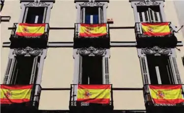  ??  ?? MADRID: Spanish flags hang from the windows of a residentia­l building in Madrid yesterday. Patriotic protests have multiplied in Spain five days before the banned referendum on the independen­ce of Catalonia. Polls show Catalans are split on the issue...
