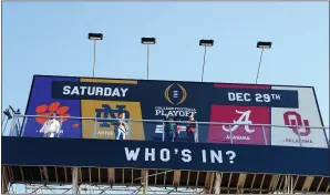  ??  ?? Chosen fans of Alabama, Oklahoma, Clemson and Notre Dame, college football teams competing for the national championsh­ip, climbed 45 feet to the billboard Thursday morning.