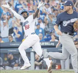  ?? JAE HONG — THE ASSOCIATED PRESS ?? The Los Angeles Dodgers’ Yasiel Puig raises his arms Wednesday after hitting an RBI single during the sixth inning of Game 5 of the NLCS against the Milwaukee Brewers.