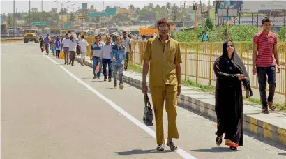  ?? PTI ?? Commuters cross the Karnataka-Tamil Nadu border on foot after the bus services were suspended amid tight security following the Supreme Court’s judgment on Cauvery water, in Bengaluru, on Friday. —
