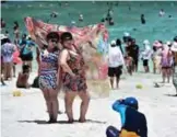  ??  ?? Tourists having their photo taken by a guide on Maya Bay, on the southern Thai island of Koh Phi Phi.