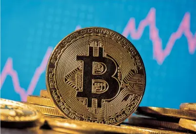  ??  ?? A representa­tion of the leading virtual currency Bitcoin is seen in front of a stock graph in this illustrati­on. Bitcoin saw its price pass US$ 30,000 on Saturday for the first time. — Reuters