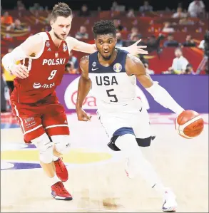  ?? Lintao Zhang / Getty Images ?? Donovan Mitchell drives around Poland’s Mateusz Ponitka during a World Cup game Saturday in Beijing, China.