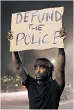  ?? BRYNN ANDERSON/AP ?? A man holds up a sign during a protest Saturday near the Atlanta Wendy’s where Rayshard Brooks was killed by police.