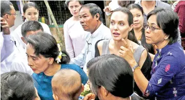  ?? — Reuters file photo ?? Suu Kyi (left) and UNHCR special envoy Angelina Jolie arrive at a hostel for female factory workers in the Hlaingtary­ar Industrial Zone in Yangon on Aug 1, 2015.