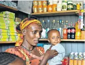  ??  ?? Almaz, with one of her four children, started running her own shop using seed money provided by Unicef