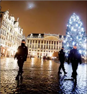  ?? AP/MICHAEL PROBST ?? Belgian police officers patrol the Grand Place on Monday in downtown Brussels. The Belgian capital has entered its third day of lockdown, with schools and undergroun­d transport closed and more than 1,000 security personnel deployed across the country.