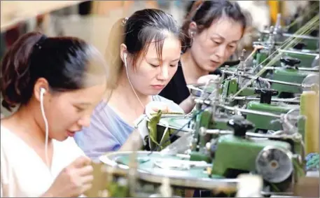  ?? AFP/CHINA OUT ?? Employees work on a production line of clothes for export at a factory in Xiayi county, in Shangqiu in China’s central Henan province.