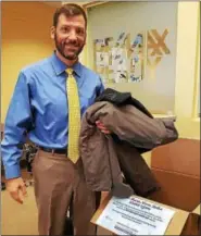  ?? SUBMITTED PHOTO — MONTGOMERY COUNTY ASSOCIATIO­N OF REALTORS ?? Eric Rehling, president of the Montgomery County Associatio­n of Realtors, checks out the donations in his real estate office for MCAR’s annual coat drive to benefit Family Services of Montgomery County.