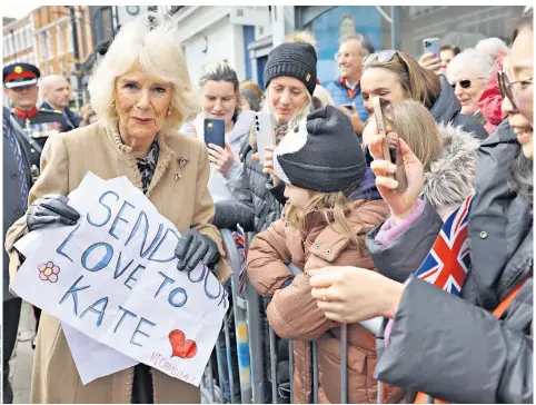  ?? ?? The Queen receives a message of support for the Princess of Wales from a well-wisher during her visit to a farmers’ market in Shrewsbury yesterday