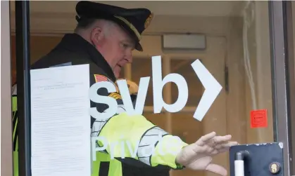  ?? Photograph: Cj Gunther/EPA ?? A police officer at Silicon Valley Bank in Wellesley, Massachuse­tts.