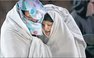  ?? AP PHOTO ?? Jeffrey Clark and Jania Carreiro try to stay warm as they and fellow shoppers wait for the doors to open at Walmart just after midnight Friday, Nov. 24, 2017, in Dartmouth, Mass.