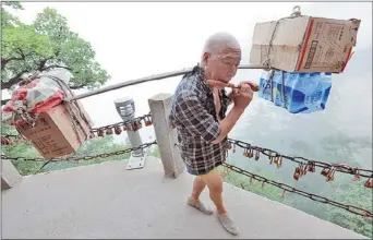  ?? LAM NGAI CHING / FOR CHINA DAILY ?? A porter plays a bamboo flute while climbing Mount Huashan in Shaanxi province.