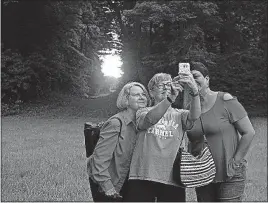  ?? [SHERIDAN HENDRIX/DISPATCH] ?? Taking a selfie with the summer solstice sunrise at Fort Ancient are, from left, Celeste Feingold, Nancy Jackson and Adrianne Harloe of Hamilton.