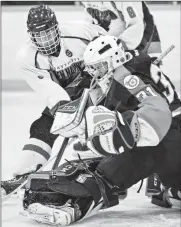  ?? Herald photo by Ian Martens ?? Lethbridge Val Matteotti Golden Hawks’ Cole Larocque tries to put the puck past Medicine Hat SEAC Tigers’ goaltender Brendan Olson during Alberta Major Bantam Hockey League action Wednesday night at Nicholas Sheran Arena.