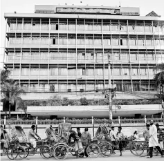  ??  ?? Commuters walk in front of the Bangladesh central bank building in Dhaka, Bangladesh. — Reuters photo