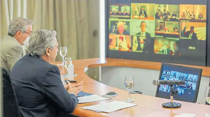  ??  ?? Videconfer­encia. Fernández, con el canciller Felipe Solá, participa ayer de forma virtual de su primera cumbre del Mercosur como presidente. Pidió ”superar la pandemia”.