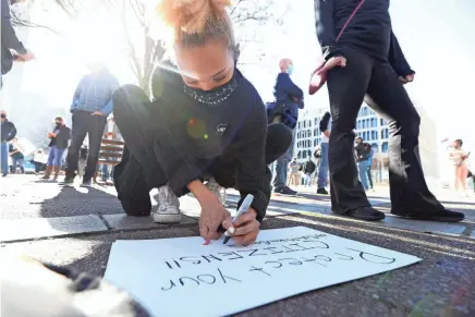  ?? JOE RONDONE/THE COMMERCIAL APPEAL ?? Ciara Fisk, a server at Lafayette’s, creates a sign as people gather on Monday to protest the threat of restaurant closures. The Safer at Home order stopped short of prohibitin­g indoor dining at restaurant­s.