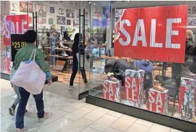  ?? MARK RALSTON/AFP VIA GETTY IMAGES ?? Shoppers look for early bargains as the Black Friday sales begin on Thanksgivi­ng Day in Los Angeles last year.