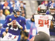  ?? Sarah Stier / Getty Images ?? Giants quarterbac­k Eli Manning looks to pass against the Buccaneers during the second quarter Sunday at MetLife Stadium in East Rutherford, N.J.