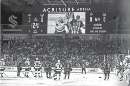  ?? PHOTOS BY TAYA GRAY/THE DESERT SUN ?? Players pause to watch a fight break out between Coachella Valley Firebirds forward Ian McKinnon (21) and Ontario Reign Jacob Doty (37) during the first period at Acrisure Arena in Palm Desert on Wednesday.