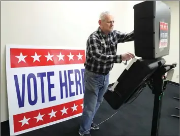  ?? The Sentinel-Record/File photo ?? POLL SETUP: Garland County Election Commission Chairman Gene Haley sets up one of the county’s voting machines at Hot Springs Mall in February.