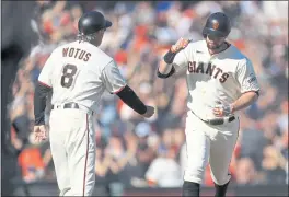  ?? SHAE HAMMOND — BAY AREA NEWS GROUP ?? The San Francisco Giants’ Brandon Belt (9) high fives third base coach Ron Wotus (8) after hitting a solo home run against the Los Angeles Dodgers in the first inning at Oracle Park in San Francisco on Sunday.