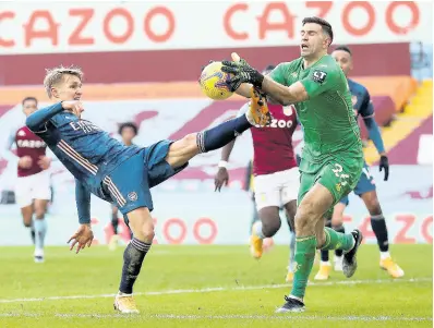  ?? FILE ?? Aston Villa’s Argentine goalkeeper Emiliano Martinez (right) challenges for the ball with Arsenal’s Martin Odegaard during an English Premier League match on February 6.