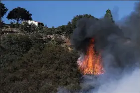  ?? RINGO H.W. CHIU — THE ASSOCIATED PRESS ?? A wildfire burns near a home Wednesdain Goleta, Calif. A wildfire raging through Southern California coastal mountains threatened ranches and rural homes and kept a major highway shut down.