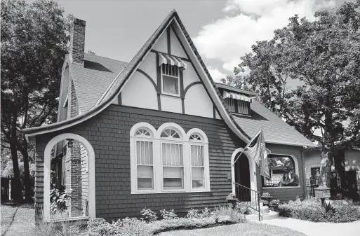  ?? Photos by Kin Man Hui / Staff photograph­er ?? With red-painted wood shake siding and stucco and trim gables, Rachel and Larkin O’Hern’s home is English Cottage style with a fairy-tale roofline.