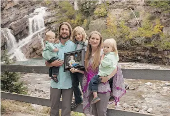  ??  ?? David and Collet Stephan pose with their children, from left, Enoch, 1, Ezra, 8, and Ephraim, 3, while holding a photo of Ezekiel. The Stephans are on trial for failing to provide the necessitie­s of life to Ezekiel.