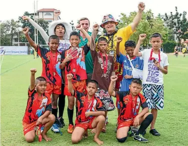  ??  ?? Children from the Nak Suu Rugby Academy with former Canadian representa­tive rugby player Eddie Evans.