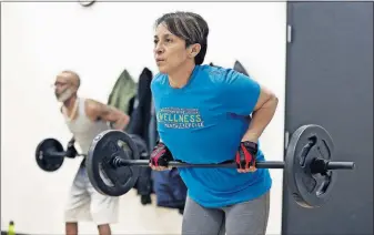  ?? [KYLE ROBERTSON/DISPATCH] ?? Experts say it’s important to include both strength training and cardiovasc­ular exercise in your workouts. Here, Nelcia Besaw lifts weights during a Body Pump class at the YMCA North branch on Sandalwood Place.