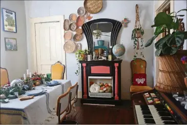  ??  ?? Musical influences and instrument­s, such as the organ, are key elements in the home. But the faux fireplace, painted dramatic black and pink, is one of Augusta Wheeler’s favorite elements. She found it at a yard sale and has it in her dining room. “I just keep repainting it for whatever my vibe is,” she said.