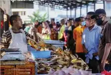  ?? ?? ORANG ramai terpaksa beratur panjang untuk mendapatka­n bekalan ayam di Pasar Ampangan, Seremban.