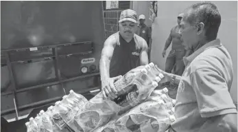  ?? CRISTIAN HERNÁNDEZ, EUROPEAN PRESSPHOTO AGENCY ?? Coca-Cola workers deliver drinks in Caracas on Tuesday. A sugar shortage has hurt production.