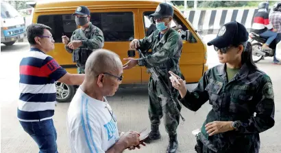  ?? Reuters ?? Philippine Army personnel check the identity of bus passengers at a check point outside Iligan on Saturday as government forces continue their assault against insurgents from the Maute group, who have taken over large parts of Marawi City. —