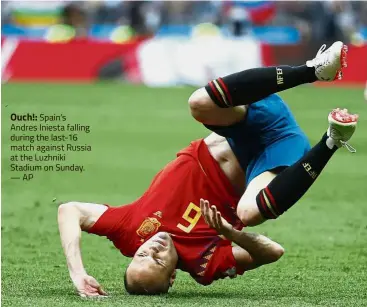  ?? — AP ?? Ouch!: Spain’s Andres Iniesta falling during the last-16 match against Russia at the Luzhniki Stadium on Sunday.