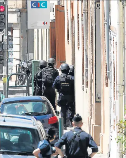  ?? GUILLAUME HORCAJUELO / EFE ?? La policia francesa munta un cordó de seguretat entorn de la sucursal bancària assaltada a Tolosa