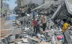  ?? | EPA ?? PEOPLE survey the damage after the house was destroyed in an Israeli air strike in Deir Al Balah, southern Gaza Strip, yesterday.