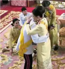  ?? — AFP ?? Warm reception: A screencap from Thai TV Pool showing Vajiralong­korn hugging his sister Ubolratana as members of the royal family look on during a ceremony in the Grand Palace in Bangkok.