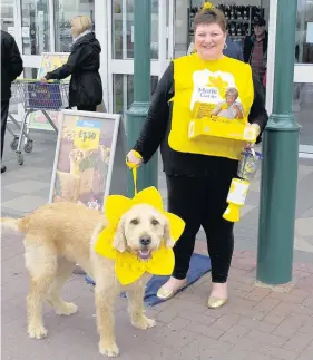  ??  ?? Jackie Pinkney collecting with labradoodl­e Jimmy for the Marie Curie Great Daffodil Appeal at Southport, in Morrisons